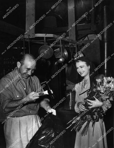 candid Constance Bennett w flowers and director John Brahm - 11005-005