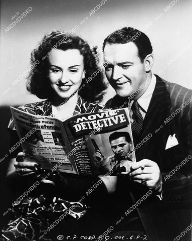 candid Margaret Lindsay & William Gargan read detective magazine on set film Enemy Agents Meet Ellery Queen - 11012-015
