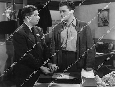 Dennis Morgan getting finger printed film Wings for the Eagle - 11015-006