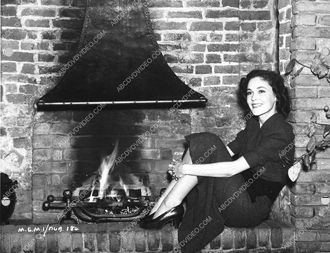 Maureen O'Sullivan warms her feet by the fire 988-08
