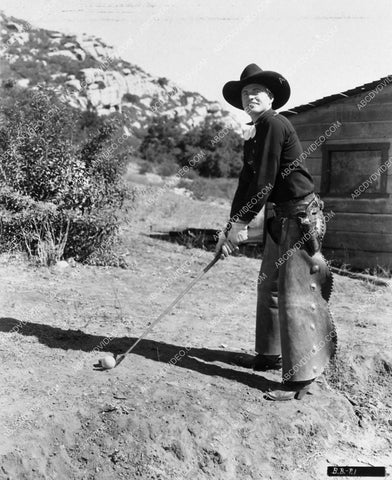 cowboy star Bob Baker practicing his golf swing 1595-29