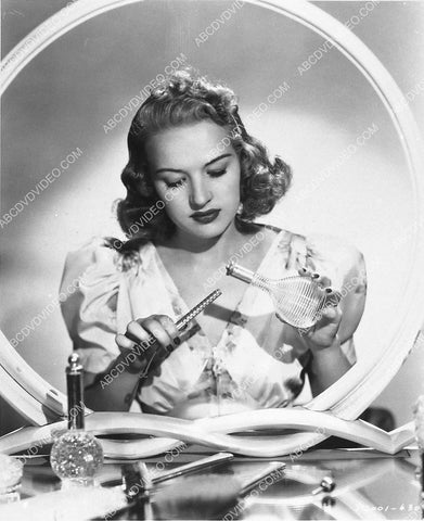 Betty Grable w a bottle of perfume and some cosmetic device 3030-02