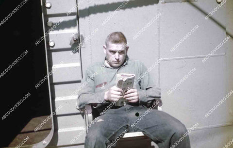 circa 1956 U.S. sailor does a little reading on deck aircraft carrier USS Shangri-La 35m-16478