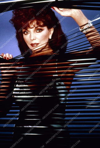Joan Collins looking through the blinds 35m-2261