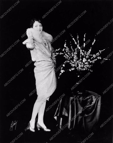 Janet Gaynor in her new dress posing w a floral arrangement 6273-29