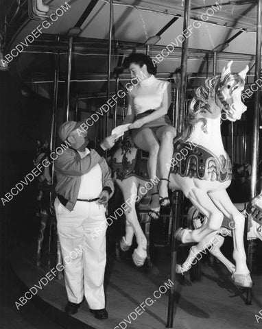 cute model sitting on carousel horse 8B11-781
