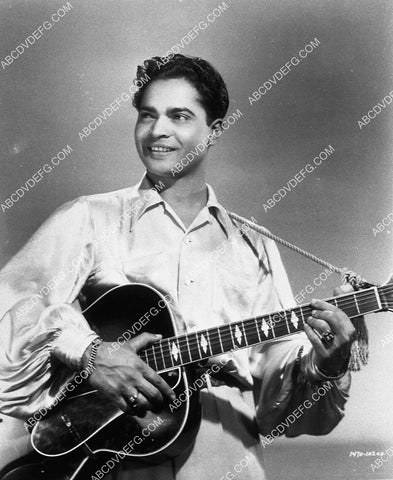 Sabu strumming a guitar 9472-29