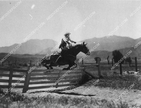 Roy Rogers and Trigger jumping over a fence 9472-31