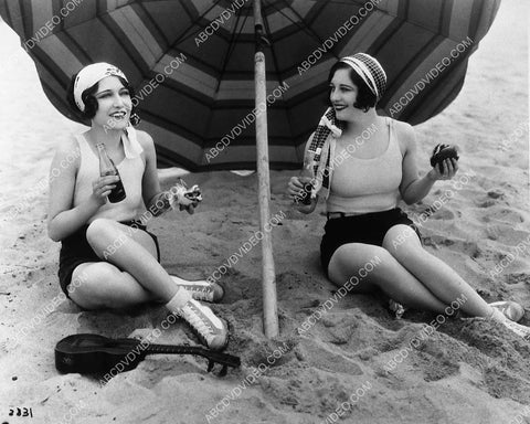Joan Crawford and friend have a coke and hot dog on the beach 9694-14