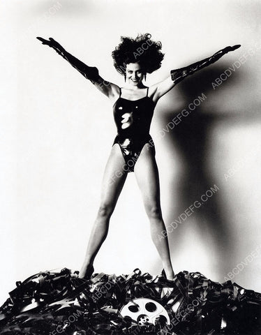 Sigourney Weaver in latex swimsuit on a pile of film 8b20-0589