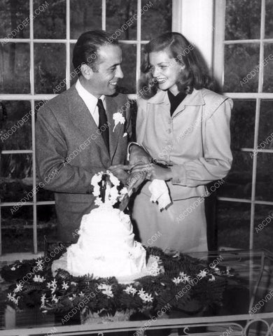 Humphrey Bogart Lauren Bacall cutting their wedding cake 8b20-14023