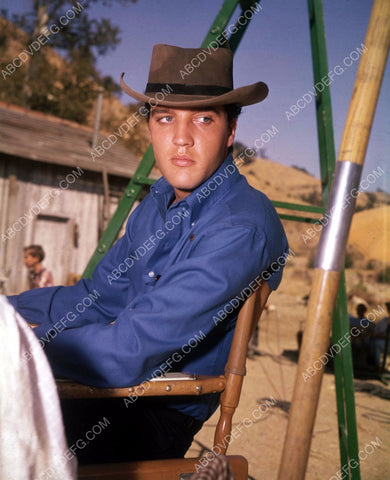 candid Elvis Presley sitting in his chair on western set 8b20-14540