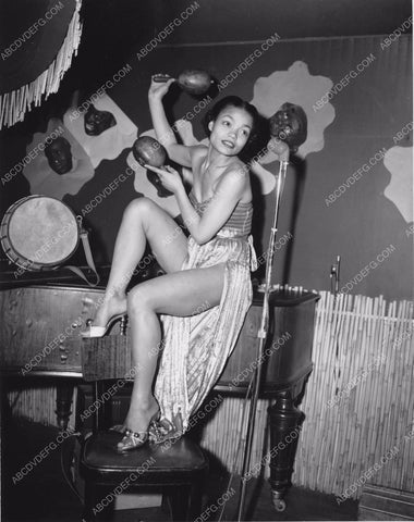 Eartha Kitt w her maracas sitting on a piano 8b20-16655