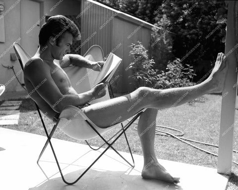 Clint Eastwood relaxing in his swim trunks reads his script 8b20-17955