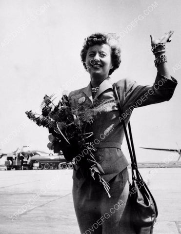 Barbara Stanwyck with a bundle of flowers at the airport 8b20-3591