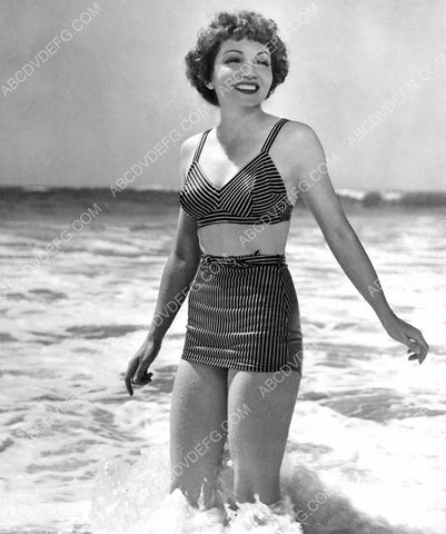 Claudette Colbert in her bikini standing in the waves 8b20-8832