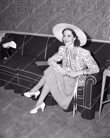 Loretta Young on sofa in hat lyoung-27