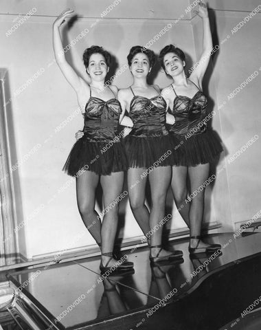 crp-13851 1945 news photo triplet sister dancers Patricia, Prudence & Priscilla Ward Triplets pose on a piano crp-13851